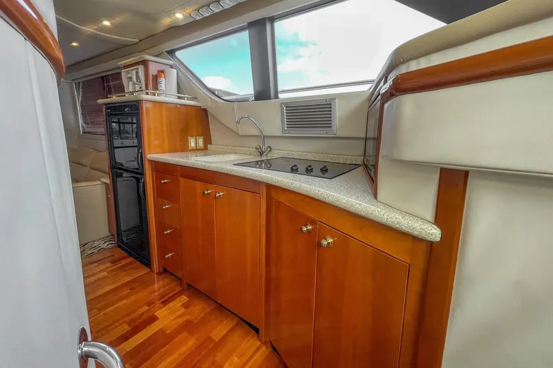 Slide: The Image of Luxurious kitchen interior of 2000 Carver 450 Voyager Pilothouse yacht with wood cabinetry. - 54