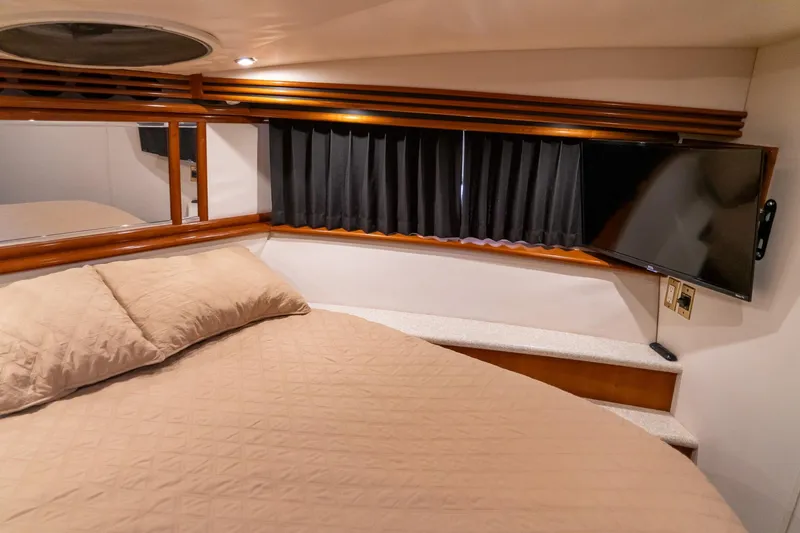 Slide: The Image of Cozy bedroom in 2000 Carver 450 Voyager Pilothouse with TV and elegant wood accents. - 60