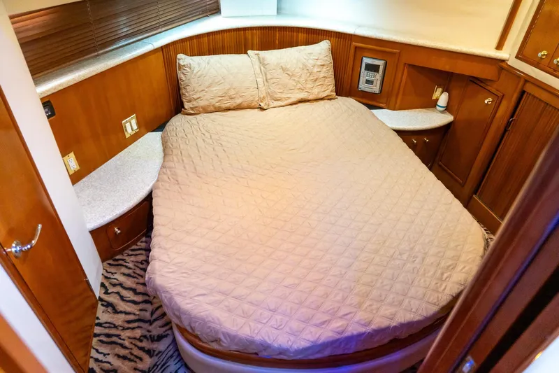 Slide: The Image of Cozy bedroom in 2000 Carver 450 Voyager Pilothouse yacht with wood accents and plush bedding. - 64