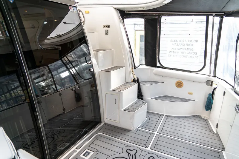 Slide: The Image of 2000 Carver 450 Voyager Pilothouse yacht interior with steps and safety warning sign. - 13