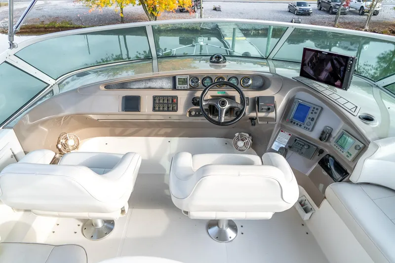 Slide: The Image of Pilothouse interior of 2000 Carver 450 Voyager, featuring dual white captain chairs and navigation equipment. - 21