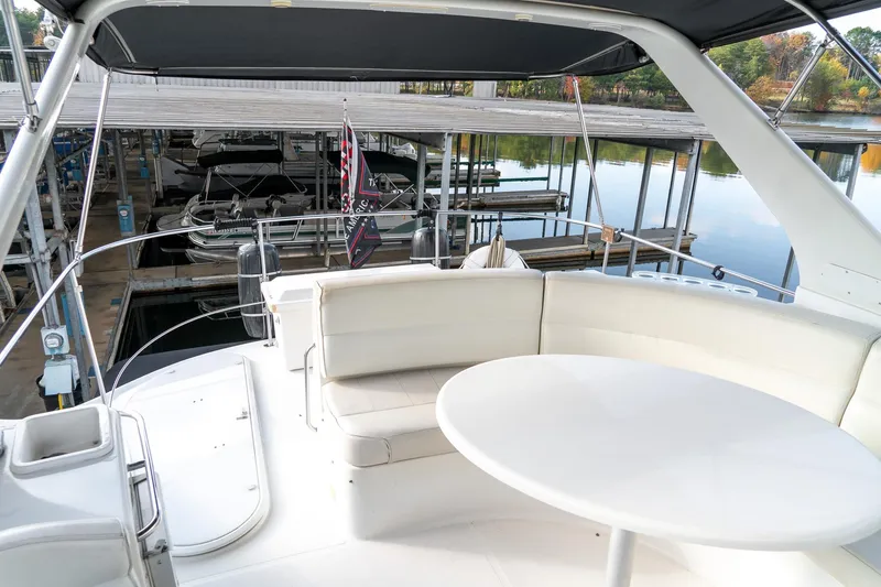 Slide: The Image of 2000 Carver 450 Voyager Pilothouse yacht with white seating and table, docked at marina. - 26