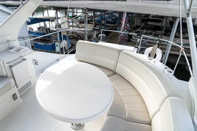 Slide: The Image of 2000 Carver 450 Voyager Pilothouse yacht with white seating and table on deck. - 27