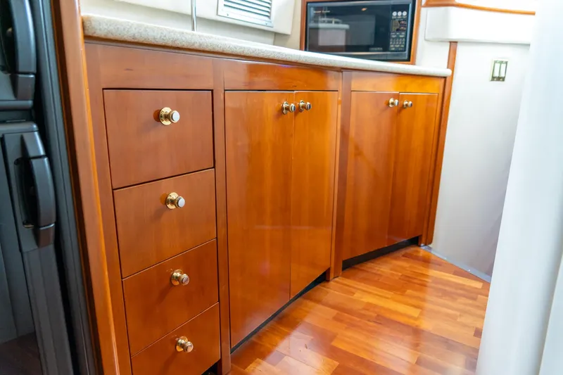 Slide: The Image of Wooden cabinetry in 2000 Carver 450 Voyager Pilothouse kitchen with microwave and drawers. - 51