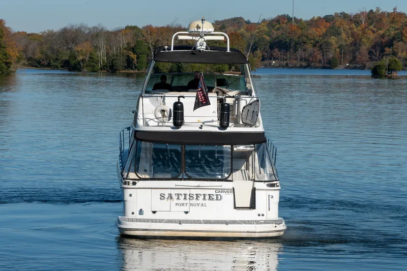 Slide: The Image of Carver 450 Voyager Pilothouse yacht on a serene lake, autumn trees in background. - 7
