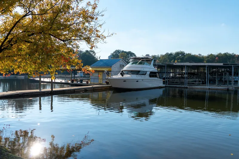 Slide: The Image of 2000 Carver 450 Voyager Pilothouse yacht docked by autumn trees. - 74
