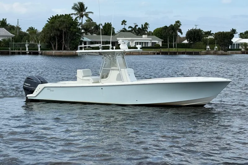 Slide: The Image of 2013 SeaVee 320B boat on calm water, featuring a sleek design and Yamaha outboard motor. - 1