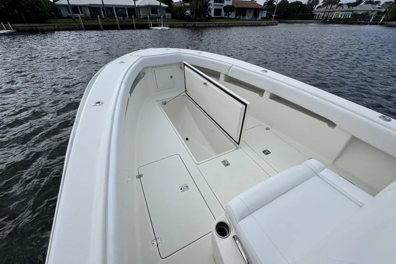Slide: The Image of 2013 SeaVee 320B boat interior with open storage compartments on calm water. - 10