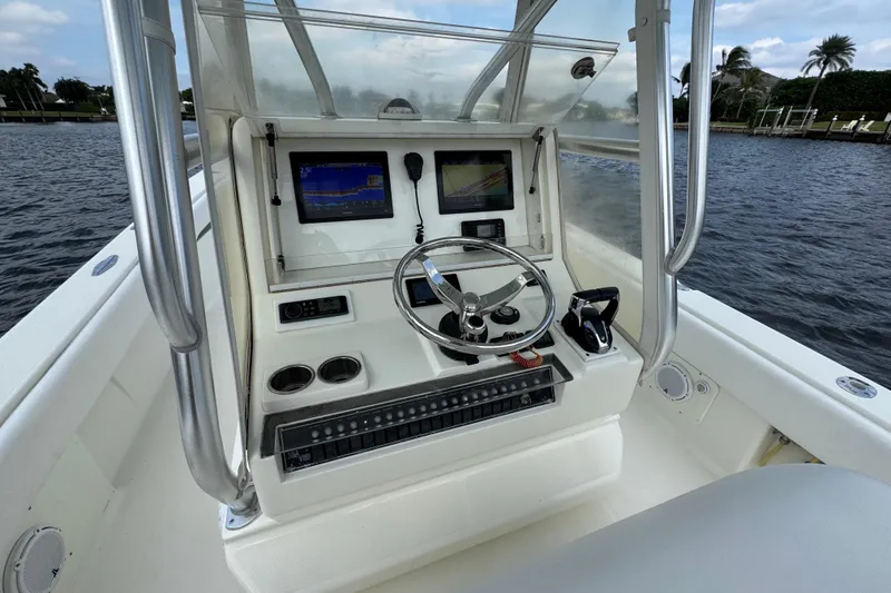 Slide: The Image of 2013 SeaVee 320B boat console with steering wheel, navigation screens, and controls on the water. - 12