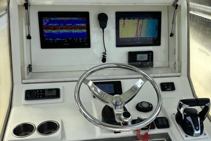 Slide: The Image of 2013 SeaVee 320B boat dashboard with steering wheel, dual displays, and controls. - 13