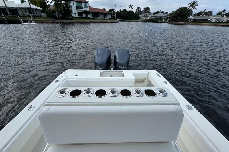 Slide: The Image of 2013 SeaVee 320B boat with dual engines, rod holders, and a scenic waterfront view. - 14