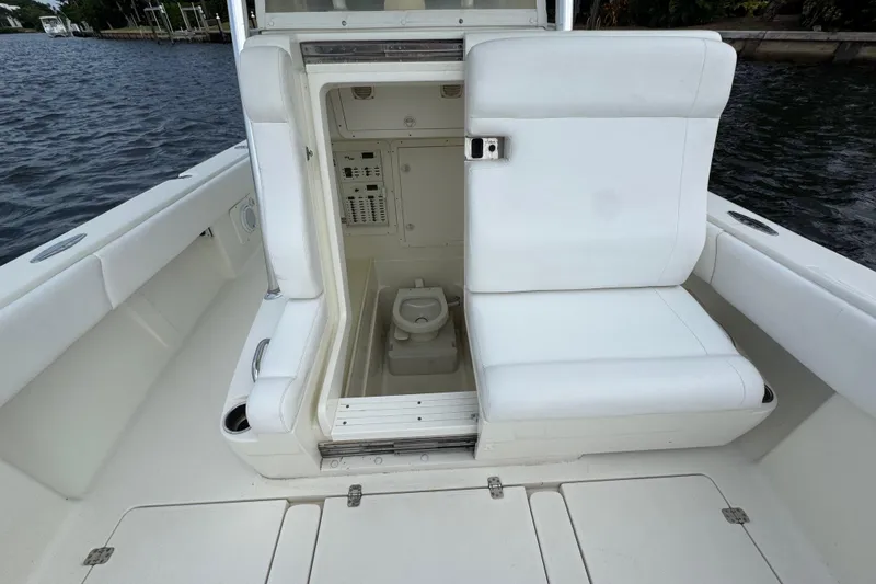 Slide: The Image of 2013 SeaVee 320B boat with open storage compartment and seating, dockside view. - 16
