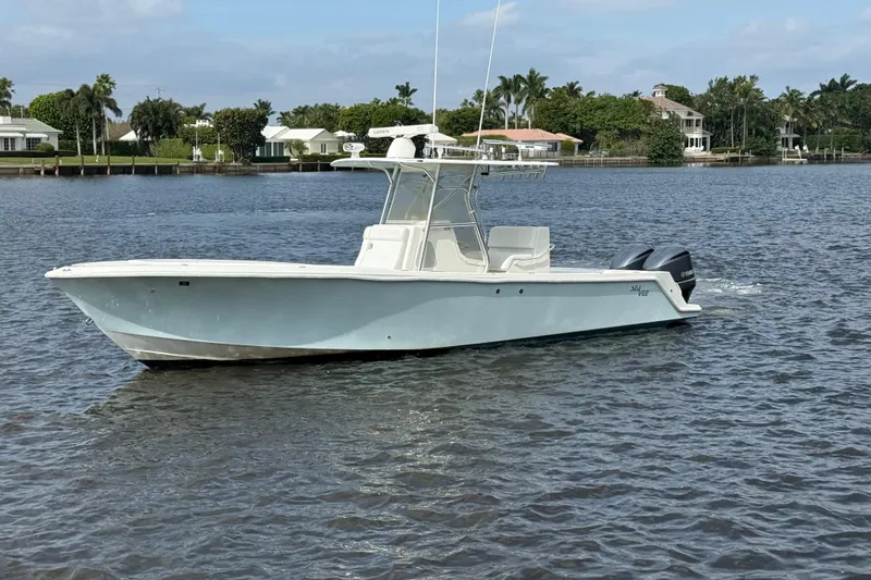 Slide: The Image of 2013 SeaVee 320B boat on calm water, surrounded by waterfront homes. - 2