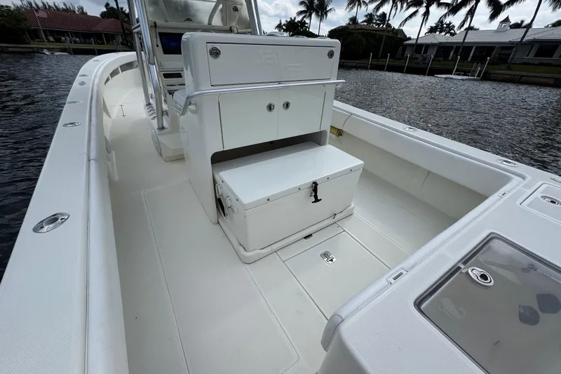 Slide: The Image of 2013 SeaVee 320B boat interior with seating and storage, docked by palm trees. - 29