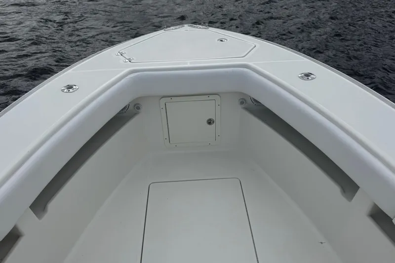Slide: The Image of 2013 SeaVee 320B boat bow, featuring sleek white design on calm water. - 7