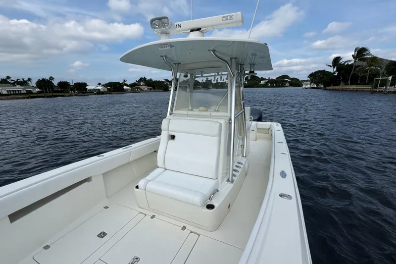Slide: The Image of 2013 SeaVee 320B boat on calm water, featuring a sleek white design and spacious deck. - 8