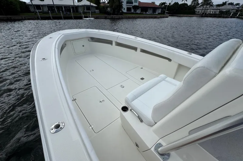 Slide: The Image of 2013 SeaVee 320B boat interior with white seating and storage compartments on calm water. - 9