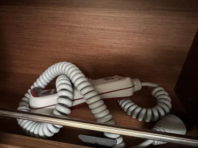 Slide: The Image of Coiled white cable in wooden compartment on Beneteau Oceanis 34.1, 2024 model. - 17