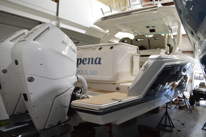 Slide: The Image of 2024 Tiara Yachts 34 LS with dual Mercury engines in a showroom. - 2