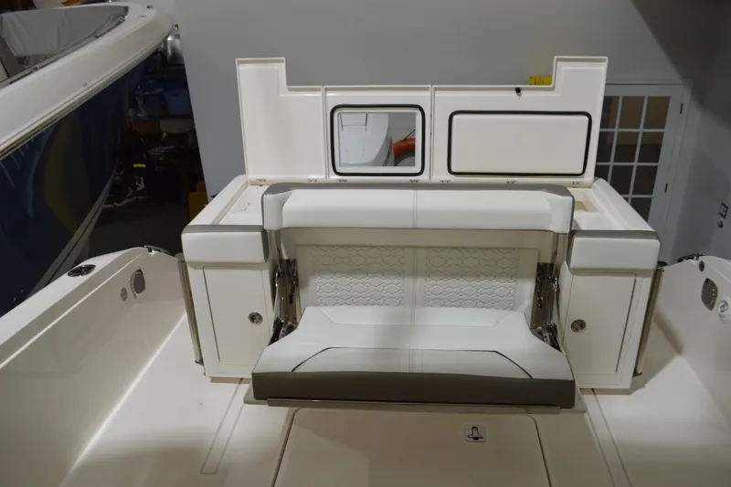 Slide: The Image of 2024 Tiara Yachts 34 LS interior with white seating and storage compartments. - 40