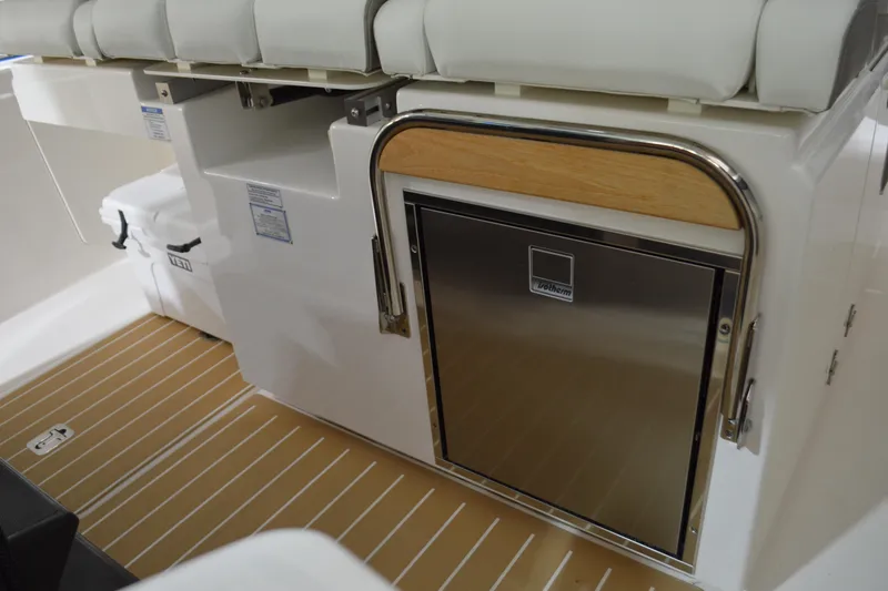 Slide: The Image of 2024 Tiara Yachts 34 LS interior with stainless steel fridge and cushioned seating. - 59