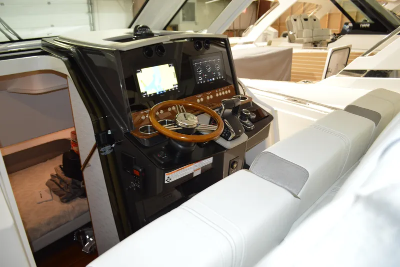 Slide: The Image of 2024 Tiara Yachts 34 LS helm with modern controls and wooden steering wheel. - 63