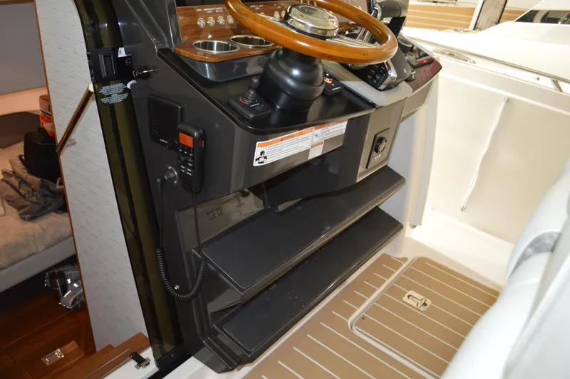 Slide: The Image of 2024 Tiara Yachts 34 LS helm with wooden steering wheel and control panel. - 66