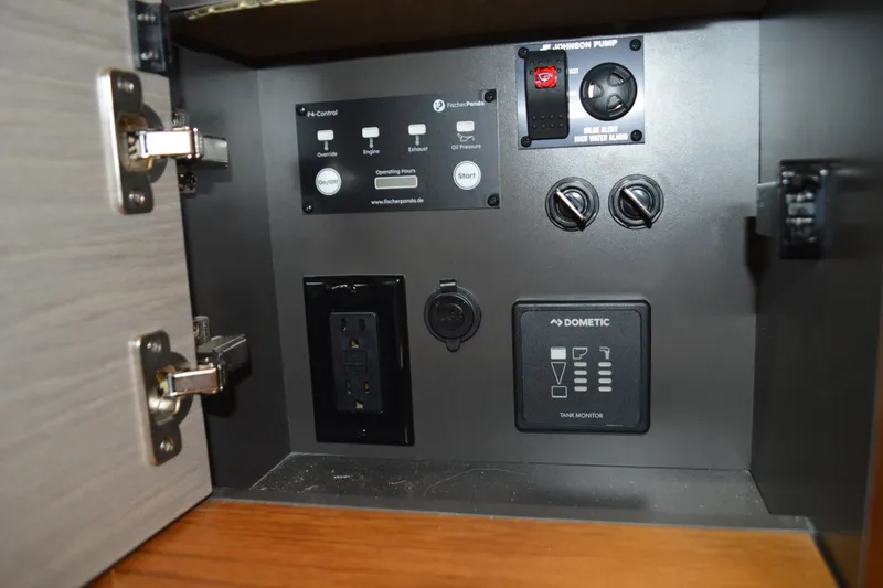 Slide: The Image of Control panel inside 2024 Tiara Yachts 34 LS, featuring switches and tank monitor. - 72