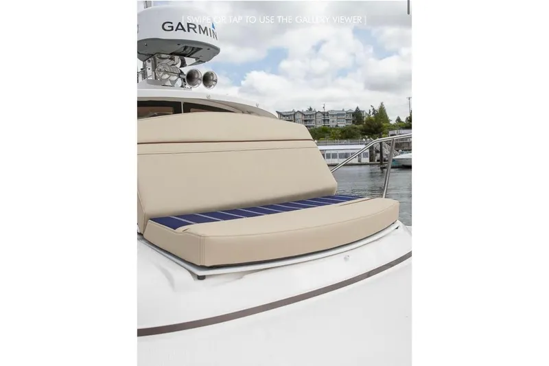 Slide: The Image of 2023 Ranger Tugs R-27 boat with beige seating and Garmin equipment, docked near waterfront. - 11