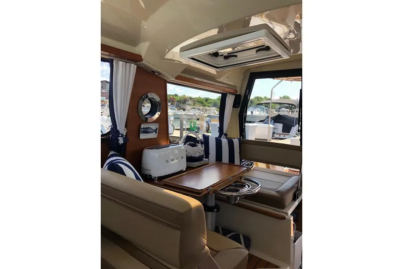 Slide: The Image of Interior of 2023 Ranger Tugs R-27 boat with seating, table, and window view. - 12