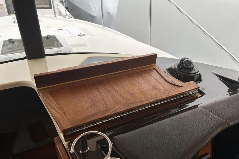 Slide: The Image of 2023 Ranger Tugs R-27 helm with wooden chart table and compass. - 14