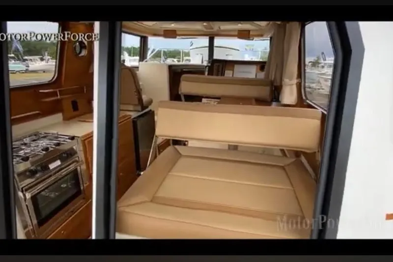 Slide: The Image of Interior of 2023 Ranger Tugs R-27 boat, featuring seating and kitchen area. - 20