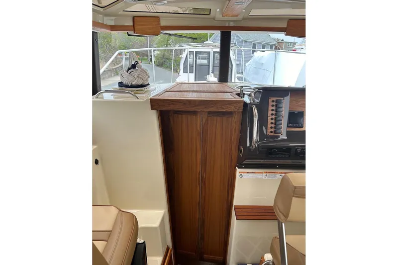 Slide: The Image of 2023 Ranger Tugs R-27 interior with wood accents and control panel. - 22