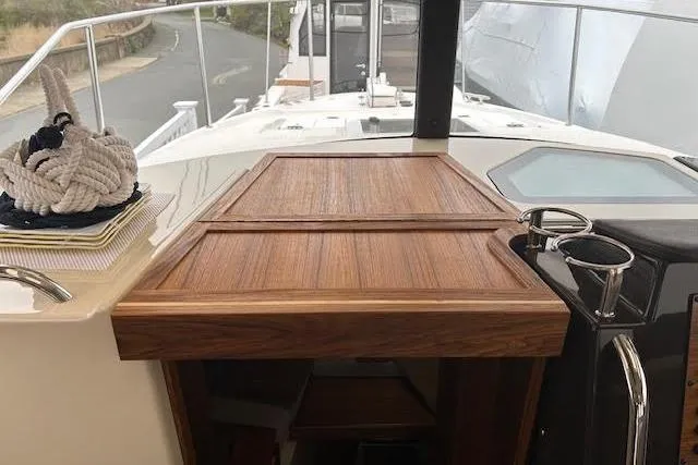 Slide: The Image of 2023 Ranger Tugs R-27 boat deck with wooden hatch and nautical rope. - 23