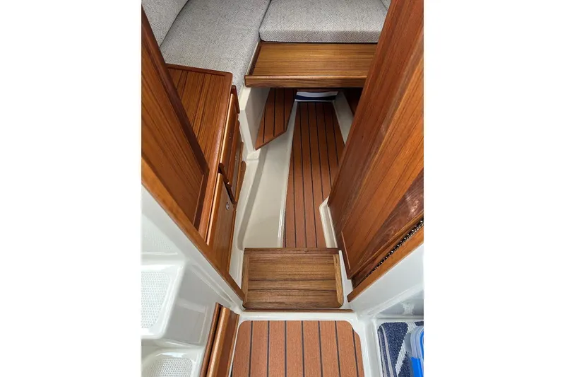 Slide: The Image of 2023 Ranger Tugs R-27 interior with wood finish and cozy seating area. - 26