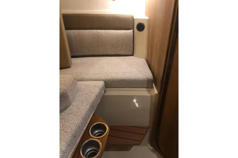 Slide: The Image of 2023 Ranger Tugs R-27 interior with cushioned seating and cup holders. - 27