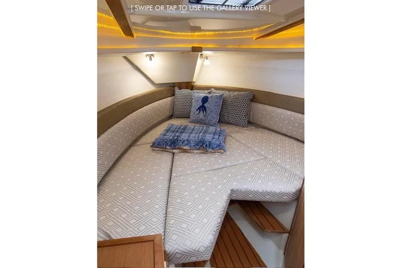 Slide: The Image of 2023 Ranger Tugs R-27 cabin interior with cozy bedding and decorative pillows. - 28