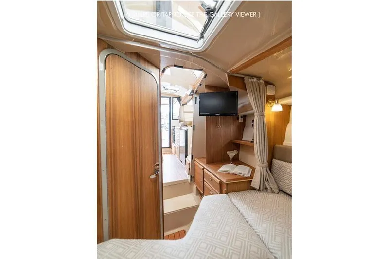 Slide: The Image of 2023 Ranger Tugs R-27 interior with cozy cabin, wood finishes, and skylight. - 30