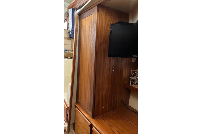 Slide: The Image of 2023 Ranger Tugs R-27 interior with wooden cabinetry and mounted TV. - 32