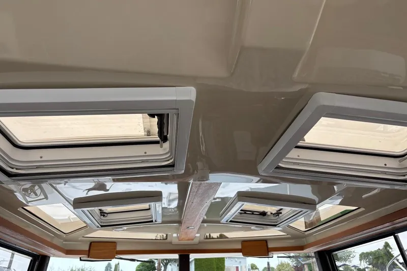 Slide: The Image of 2023 Ranger Tugs R-27 interior ceiling with multiple skylights and modern design. - 33