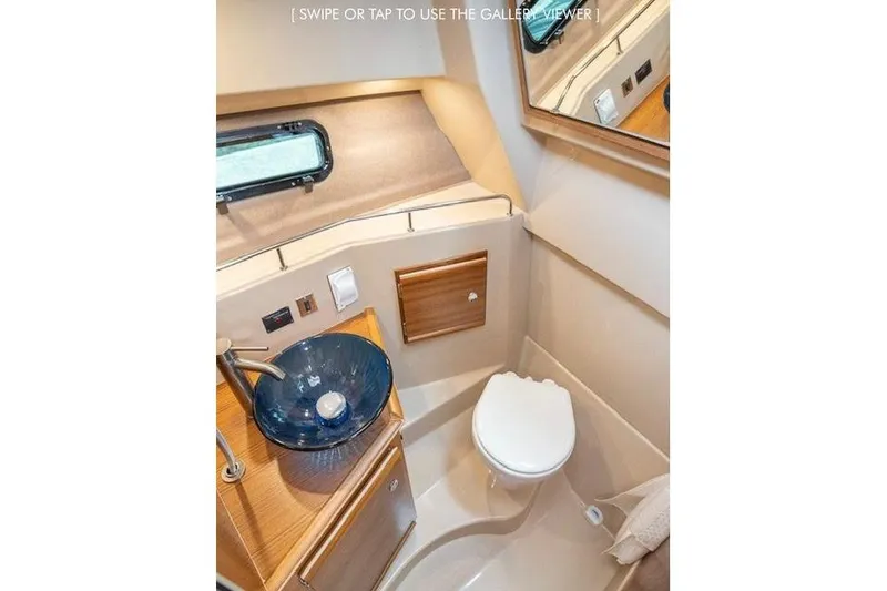 Slide: The Image of 2023 Ranger Tugs R-27 boat bathroom with modern sink and compact toilet. - 35