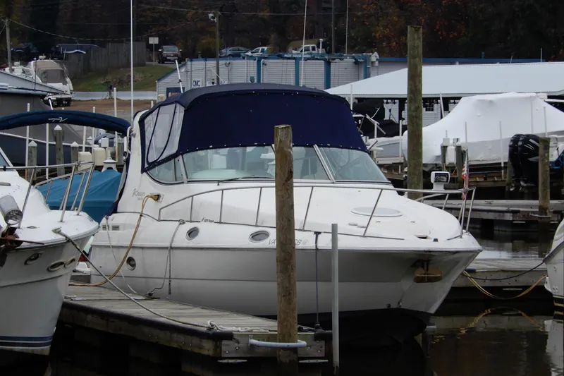 The Image of 1999 Cruisers Yachts 3075 Rogue docked at a marina, featuring a blue canopy. - 0