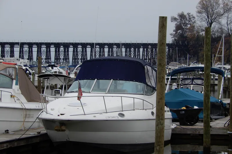 Slide: The Image of 1999 Cruisers Yachts 3075 Rogue docked at marina with bridge in background. - 2