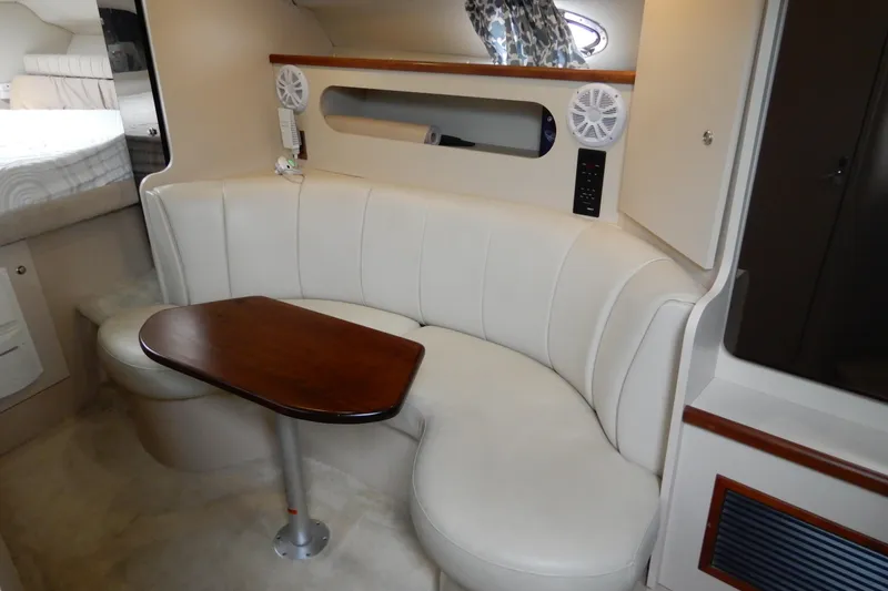 Slide: The Image of 1999 Cruisers Yachts 3075 Rogue interior with curved seating and wooden table. - 25
