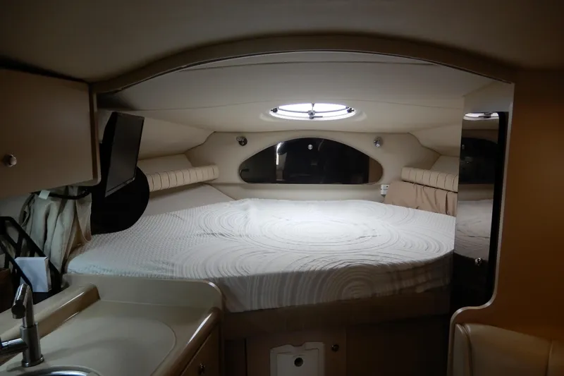 Slide: The Image of 1999 Cruisers Yachts 3075 Rogue cabin interior with bed and porthole window. - 26