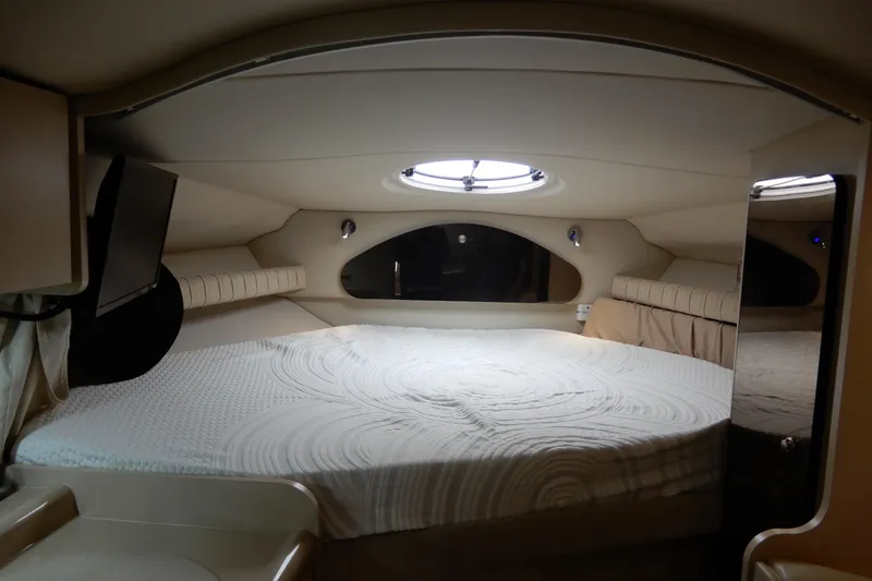 Slide: The Image of 1999 Cruisers Yachts 3075 Rogue cabin interior with bed and porthole window. - 27