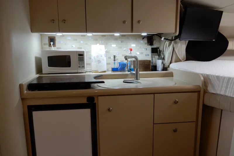 Slide: The Image of 1999 Cruisers Yachts 3075 Rogue interior kitchen with microwave, sink, and cabinets. - 28