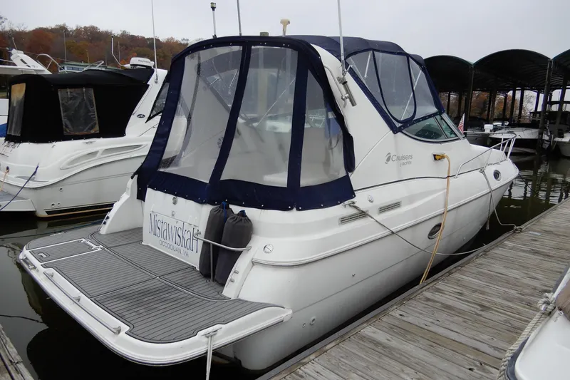 Slide: The Image of 1999 Cruisers Yachts 3075 Rogue docked at marina with blue canopy. - 3