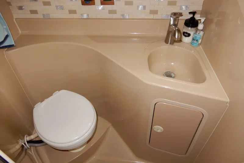 Slide: The Image of 1999 Cruisers Yachts 3075 Rogue bathroom with sink and toilet, beige interior. - 35