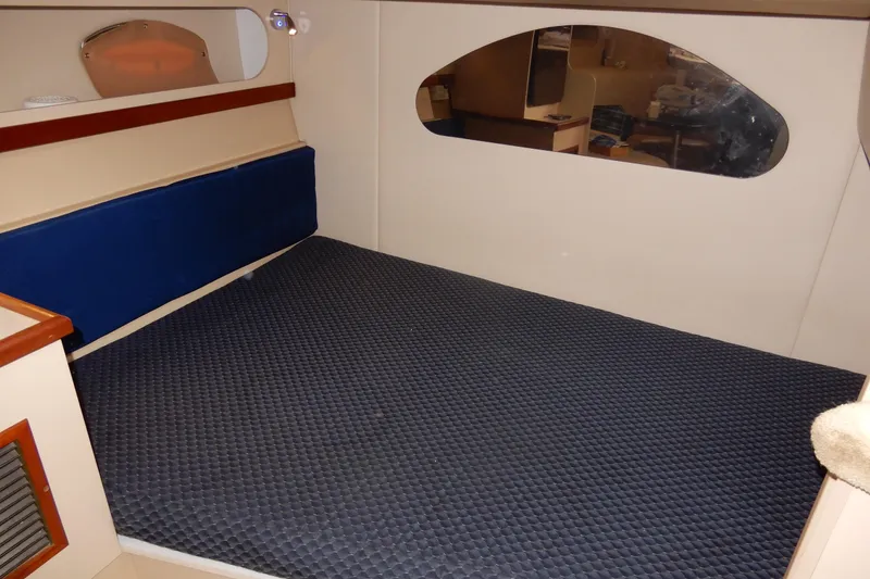 Slide: The Image of 1999 Cruisers Yachts 3075 Rogue interior cabin with blue mattress and mirror. - 36